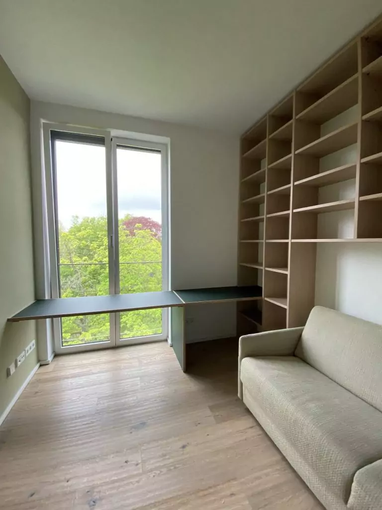 Arbeitszimmer mit Schreibtisch aus Linoleum und einem Bücherregal